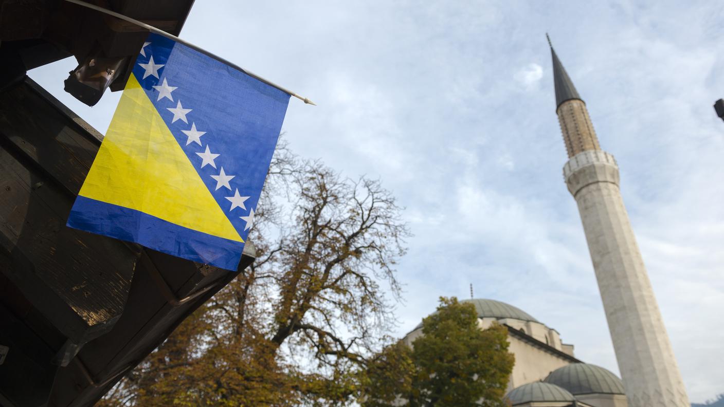 Bandiera della Bosnia Erzegovina, vicino ad una Moschea