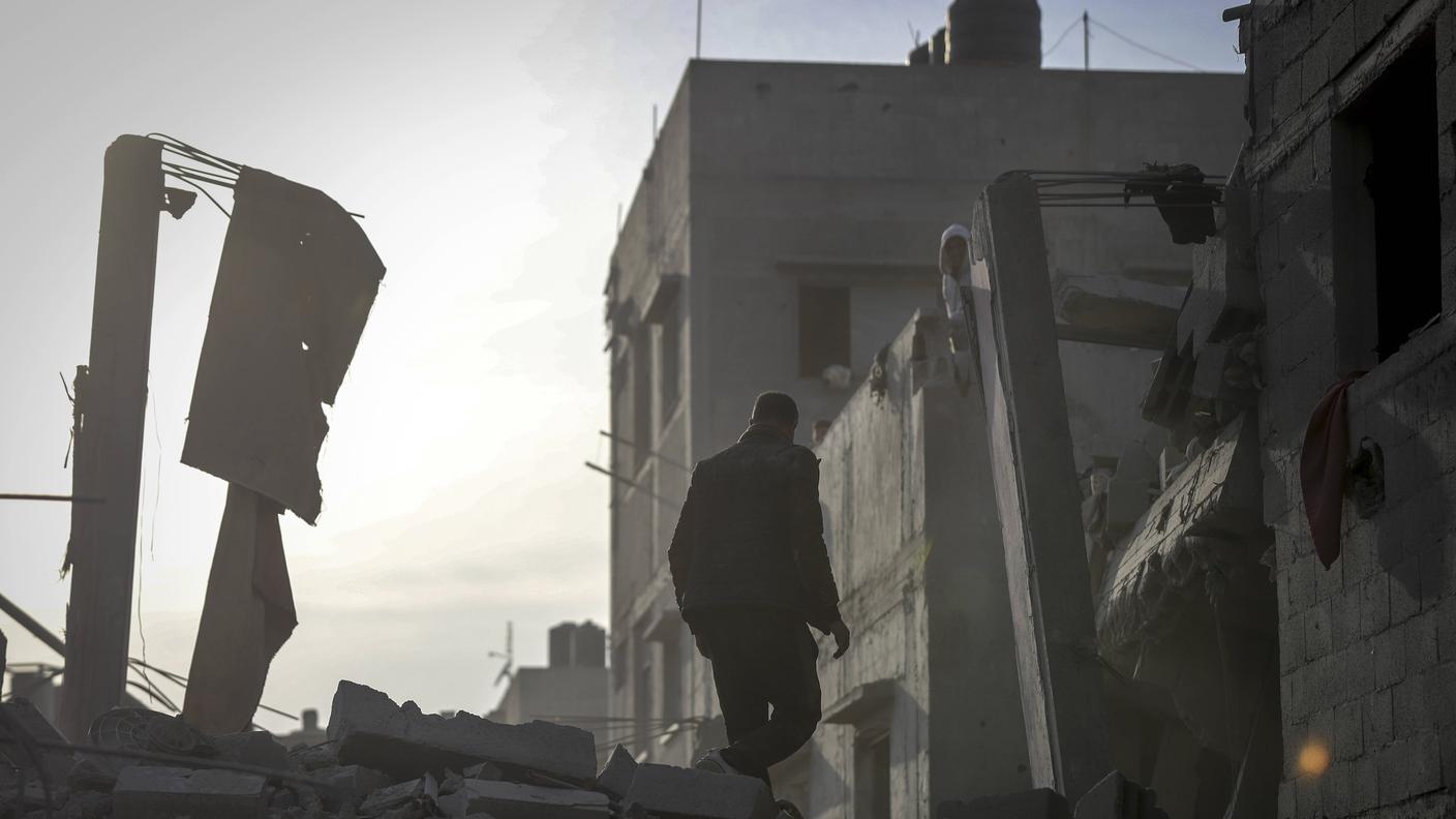 Conflitto israelo-palestinese. Un uomo attraversa le rovine di un edificio distrutto nel campo profughi di Nuseirat, nella Striscia di Gaza centrale (7 dicembre 2024).