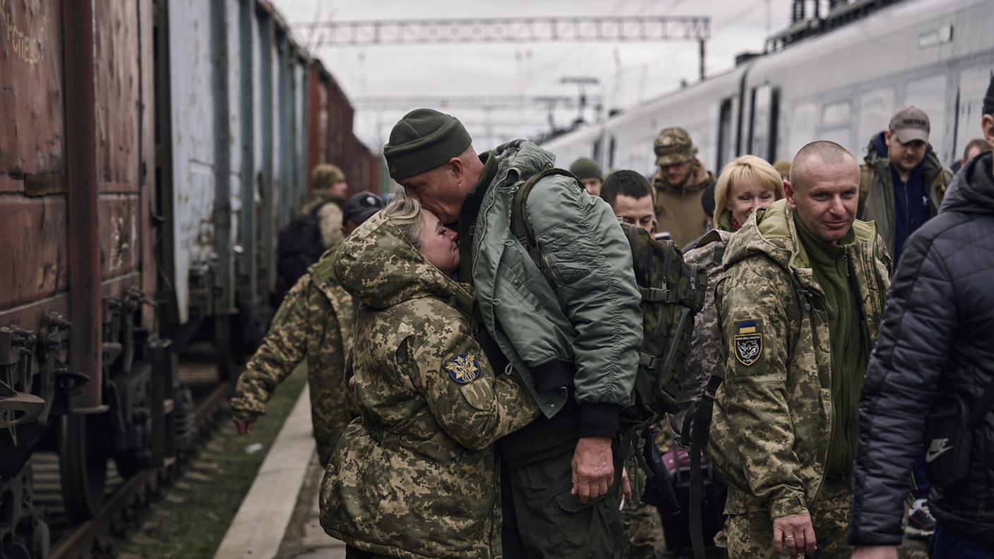 Soldatessa ucraina abbraccia il marito in stazione a Kramators'k, Oblast' di Donec'k, al ritorno dal fronte