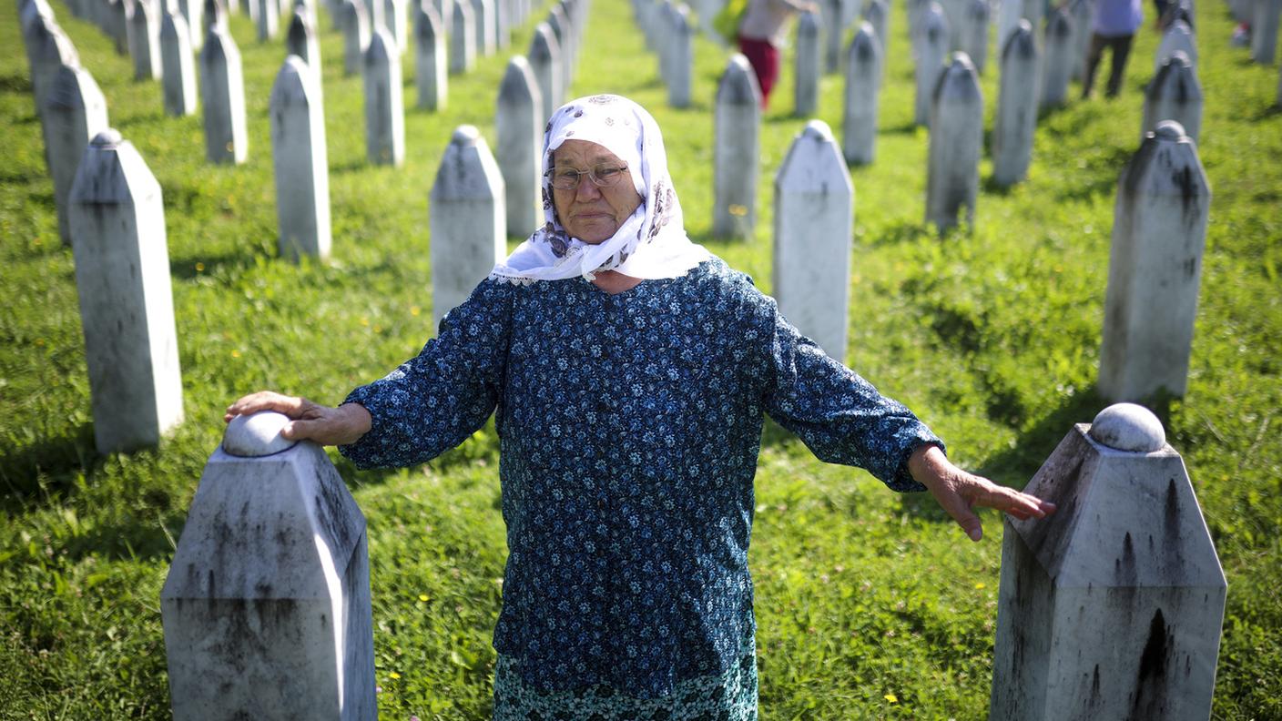 Ramiza Hasanovic piange accanto alle tombe dei suoi due figli, vittime del genocidio di Srebrenica, presso il Centro Memoriale di Srebrenica, a Potocari, in Bosnia, giovedì 11 luglio 2024