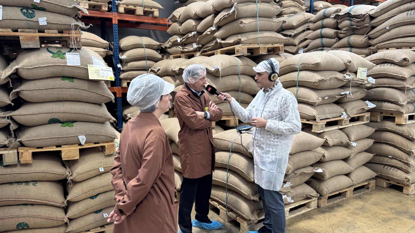 Davide Gagliardi con Vittorio Maspoli nel magazzino della Chicco d’Oro, tra sacchi di caffè pronti per la lavorazione